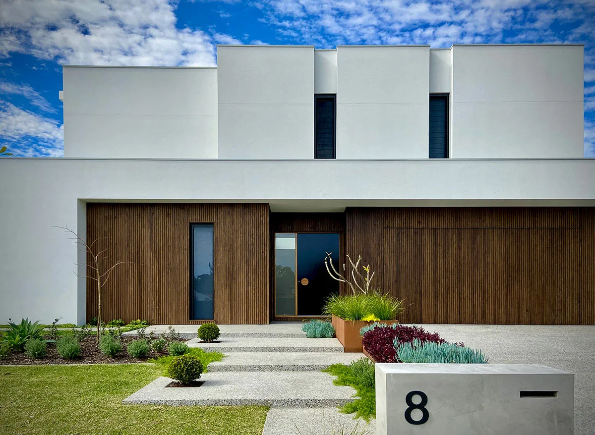 Modern home entrance with timber-slat facade and new garden bed