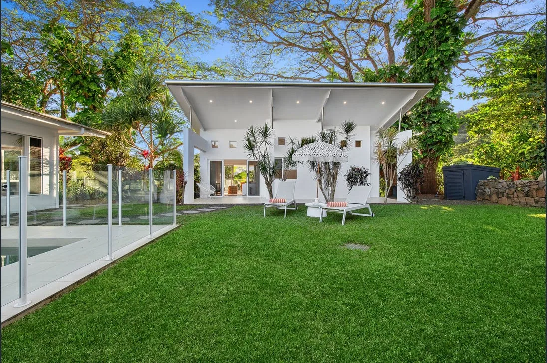 Backyard pool with glass fencing, lawn and paved surrounds